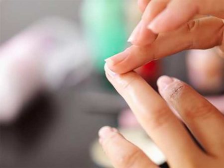 Woman applying lotion to cuticles