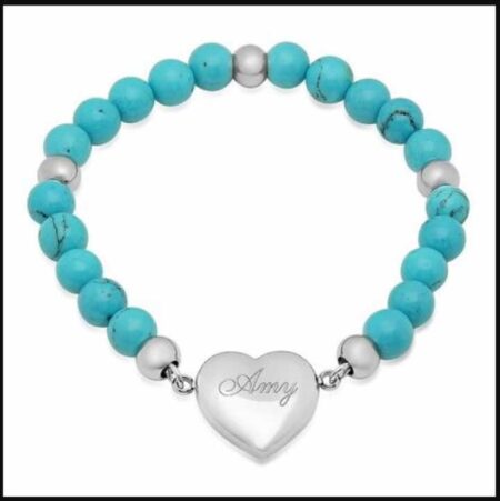 A heart charm bracelet with an engraving