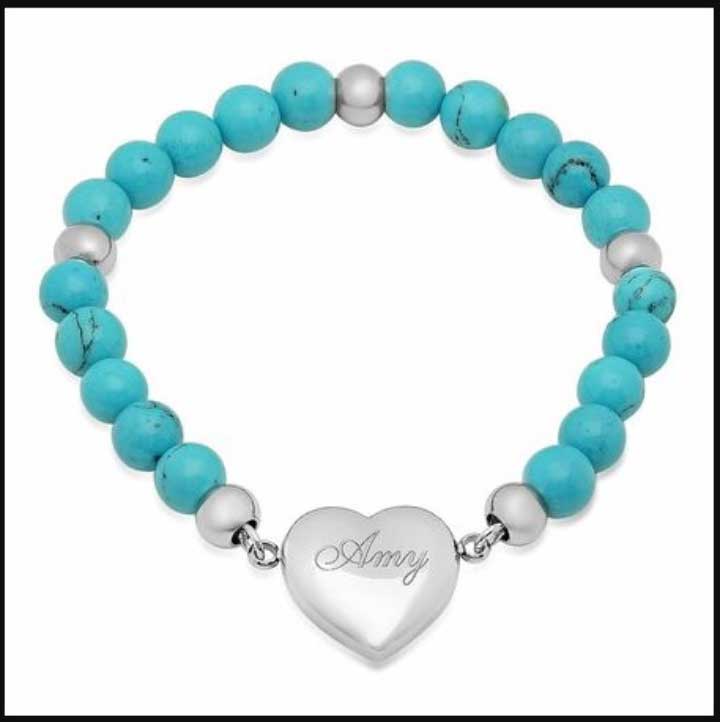 A heart charm bracelet with an engraving