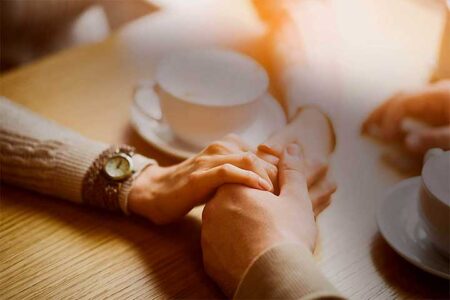 Couple holding hands in cafe
