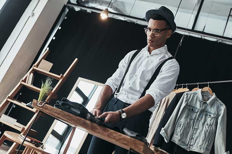 young man arranging menswear