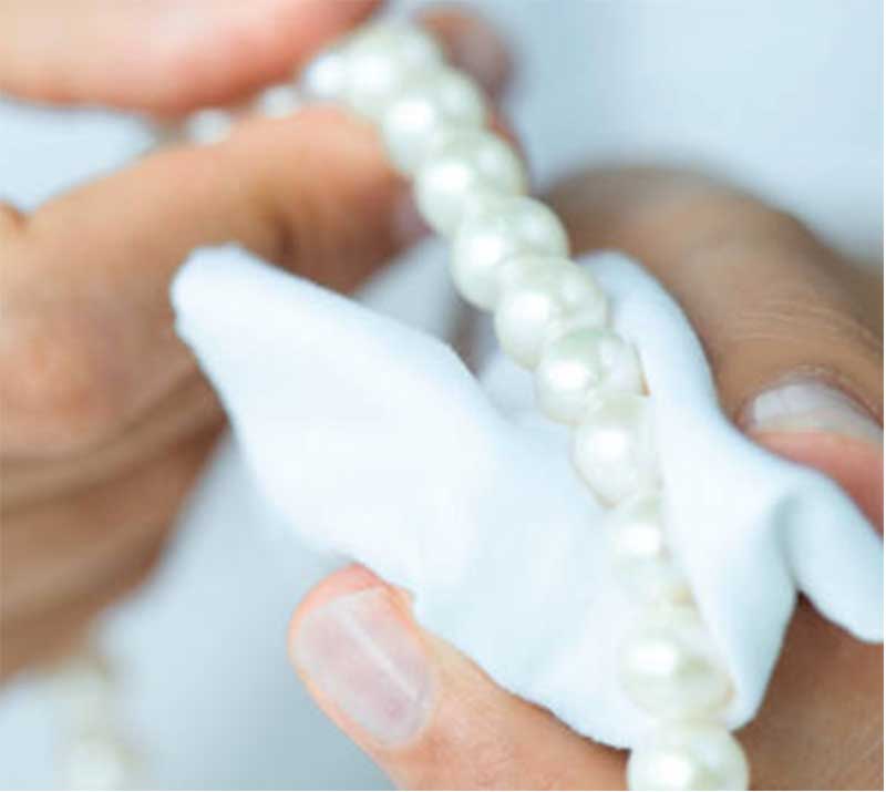 Cleaning pearl necklace with a white soft cloth
