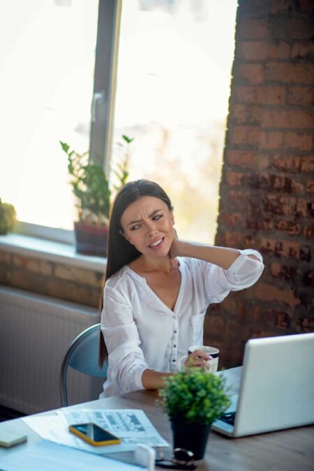 unhappy young woman feeling pain in the neck