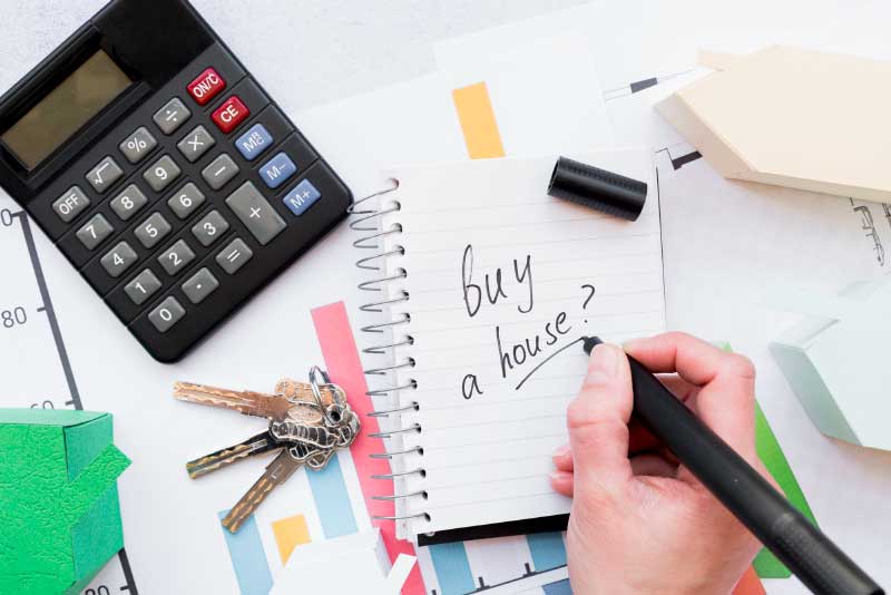 a person writing to buy a house on notepad