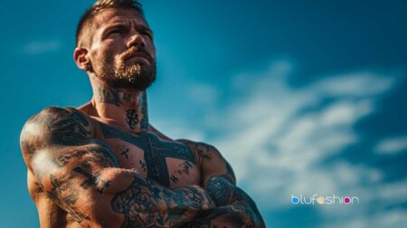 Muscular man with faith-inspired tattoos and prominent cross on shoulder.