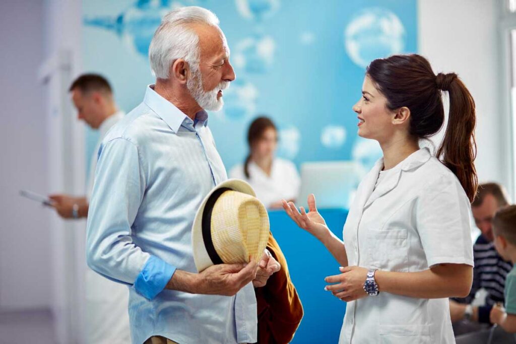 Senior man consulting with female orthopedic surgeon in clinic with a positive demeanor.