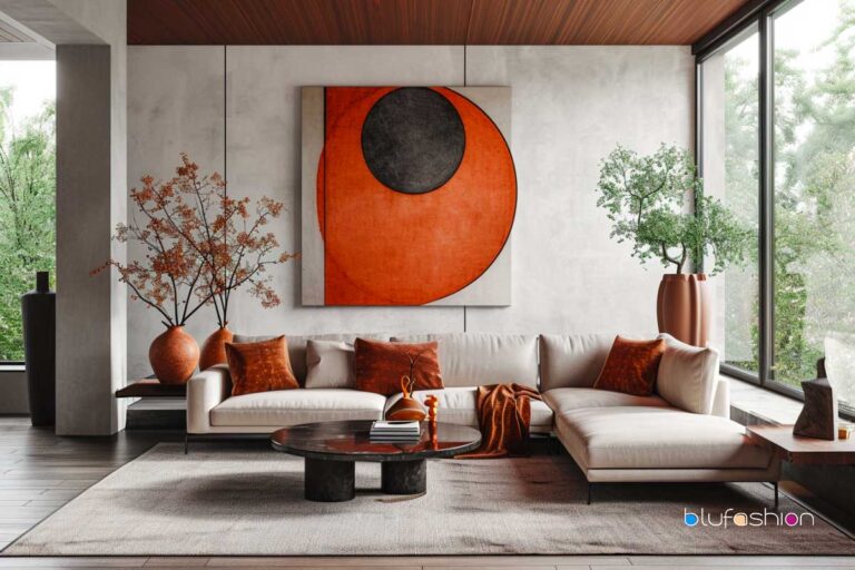 Modern living room with large abstract orange and black art, cream sectional sofa with burnt orange pillows, and nature view.