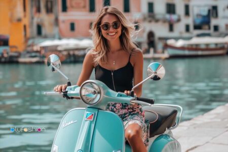 Dolce Vita Lifestyle: Joyful woman with sunglasses riding a vintage scooter by a picturesque canal.