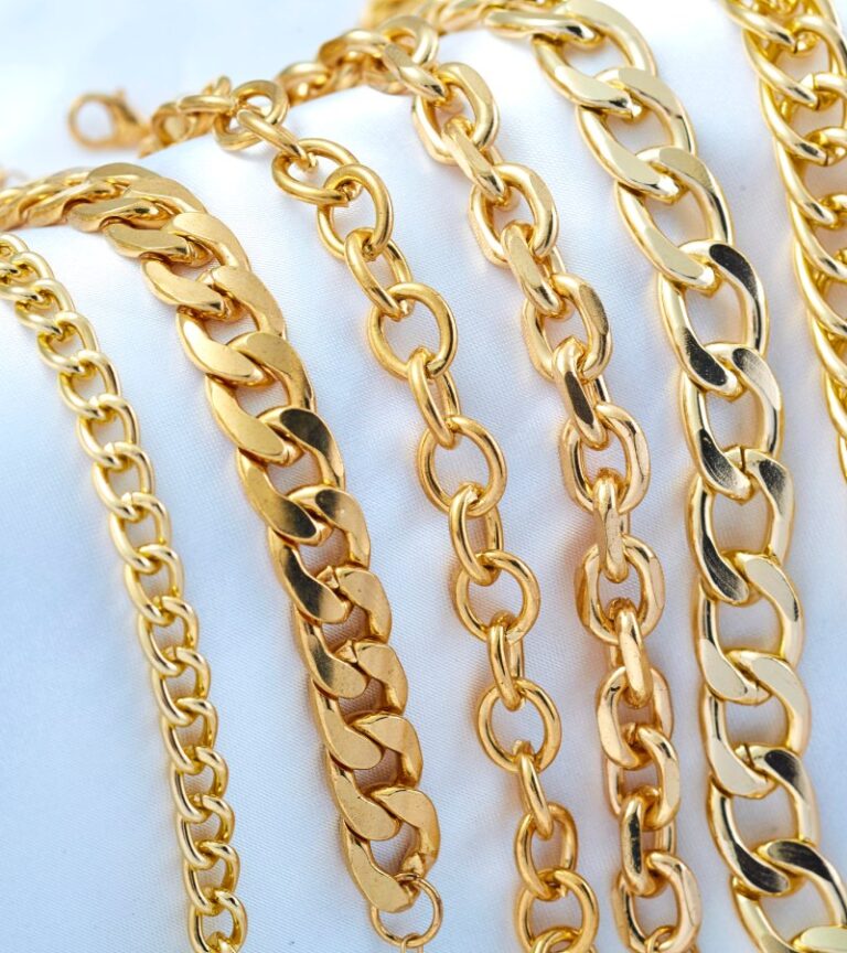Six gold link bracelets appear on a white background. Each link bracelet has a different size and shape.