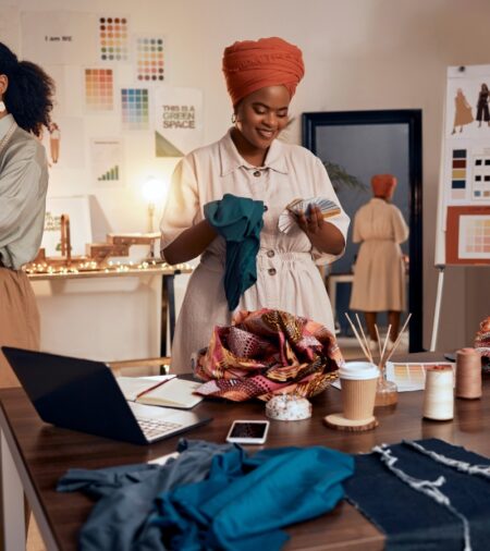 A group of small fashion business owners working together to select color palettes, fabric types, and garment styles.