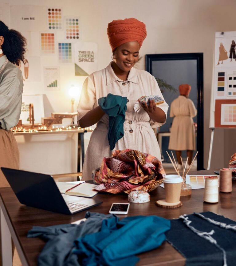 A group of small fashion business owners working together to select color palettes, fabric types, and garment styles.