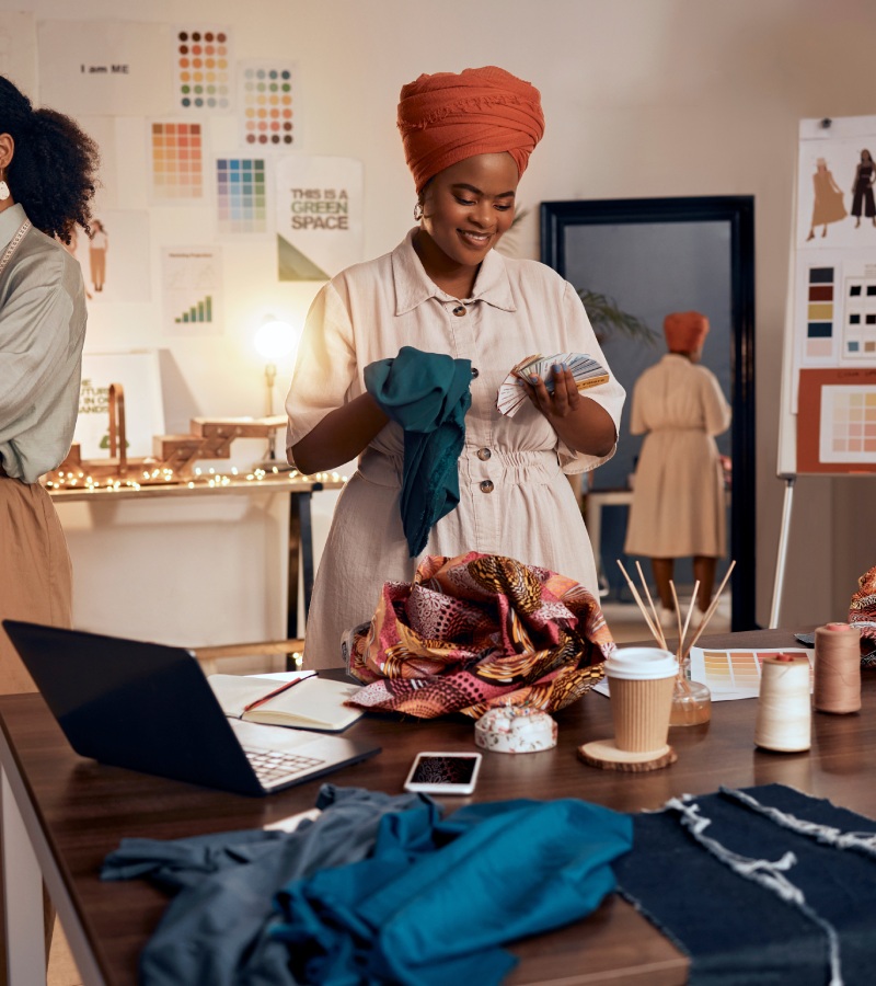 A group of small fashion business owners working together to select color palettes, fabric types, and garment styles.