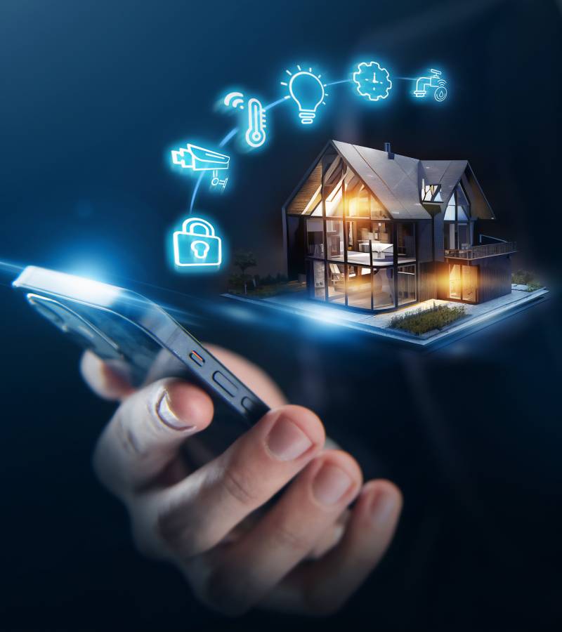 Close-up of a hand holding a phone with an image of a house near it. Other images like a lightbulb and lock, are nearby.