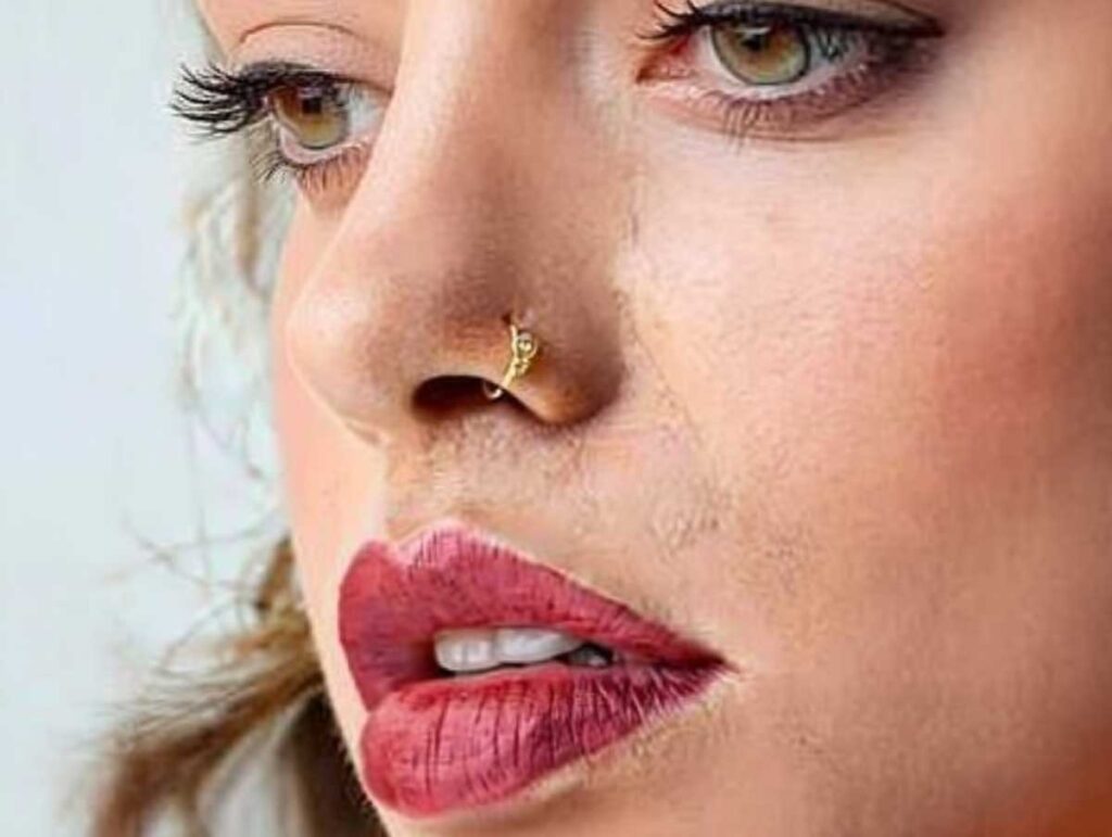 Side profile of woman with gold decorative nostril hoop