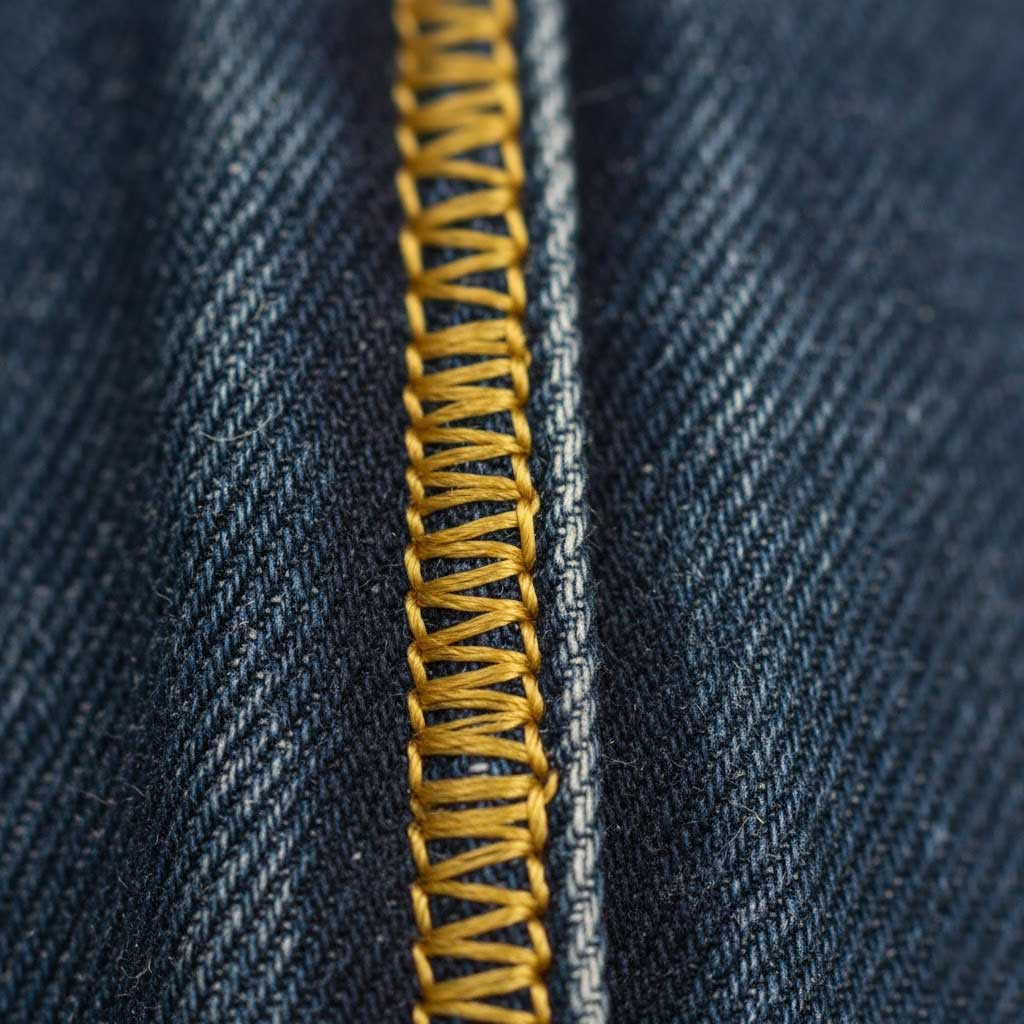 Photo of a micro close-up of a high-density stitch on a denim jacket seam.